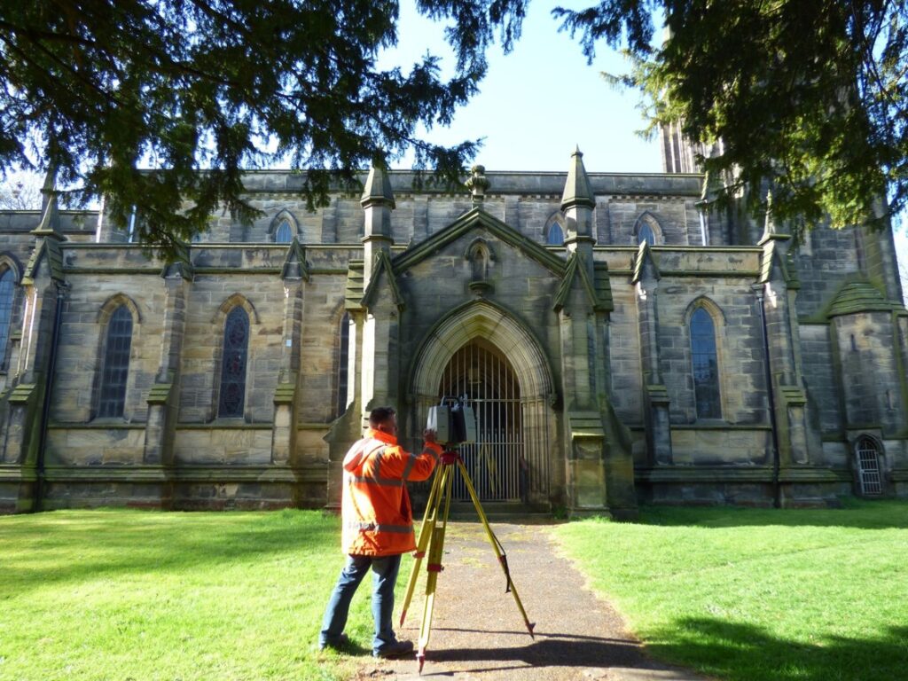 Surveyor carrying out a heritage site survey at a historic church.